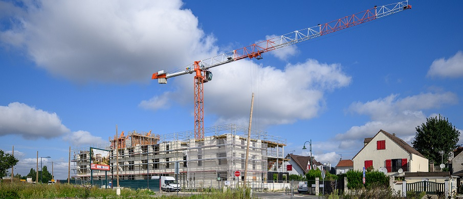 Vue d'ensemble de la future résidence, entourée d'échafaudages et avec une grue en surplomb.